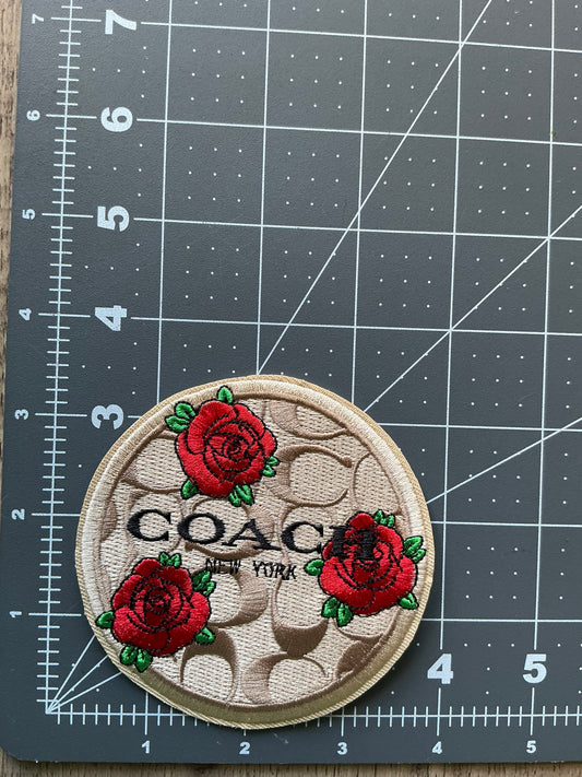 Brown coach w/ red flowers iron on patch.